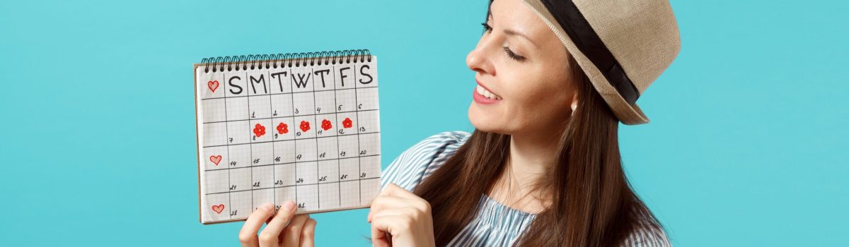 Portrait of young woman in blue dress, hat holding female periods calendar for checking menstruation days isolated on trending blue background. Medical healthcare, gynecological concept.